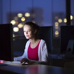 Pretty, young female college student using a desktop computer/pc