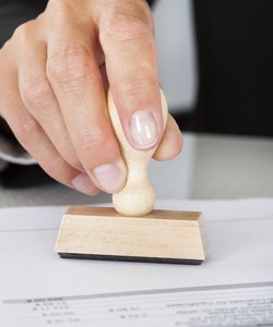 Business Man Hand Pressing Rubber Stamp On Document