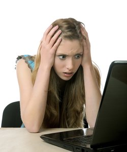 girl with horror looks at the laptop screen
