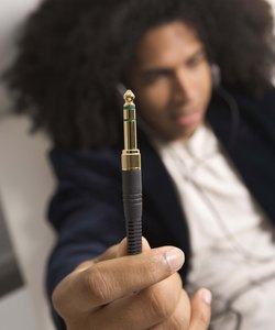 Hip man holding headphones connection prong