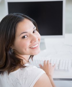 Woman at computer looking over her shoulder