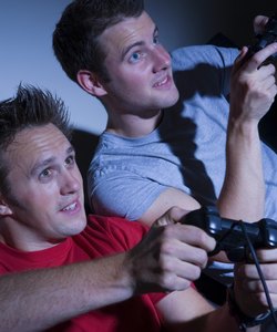 Two men playing on a games console