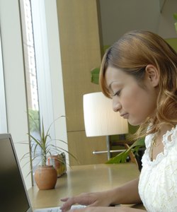 Young woman using laptop in cafe, blurred motion