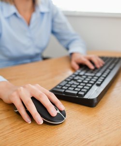 Blonde businesswoman with hands on mouse and keyboard