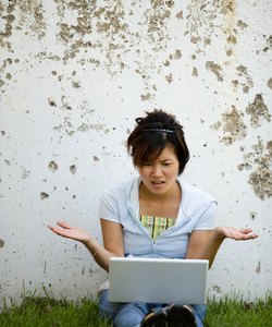 Frustrated woman on laptop computer outdoors