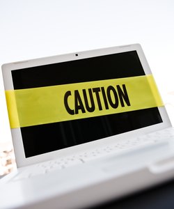 Caution tape around laptop computer