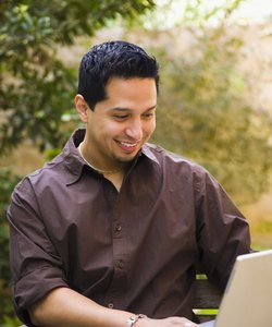 Man working on a laptop and smiling