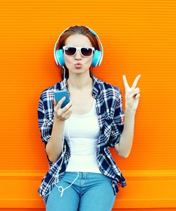 Pretty cool girl having fun and listens music in headphones