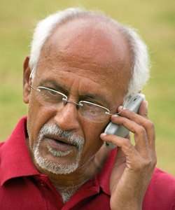 An old man talking on a cell phone