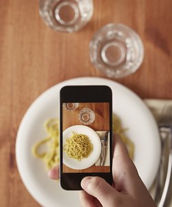 Hands taking photo of lunch with smartphone