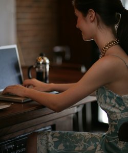Young woman using laptop at bar in cafe.