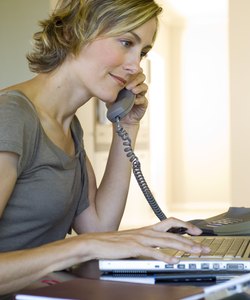 Woman talking on phone and using laptop computer