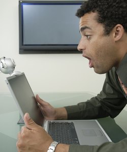 Business man looking at computer in shock