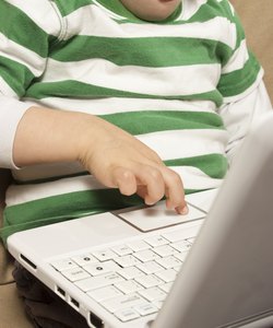Young boy uses touchpad on Netbook computer