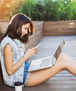 Young woman using a laptop and smart phone