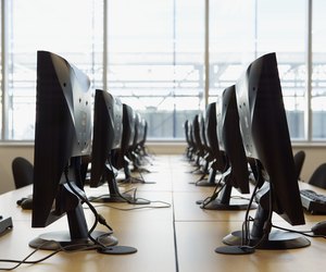 two rows of computers, flat screen monitors