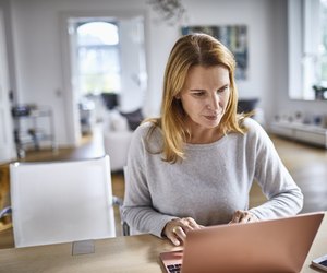 Woman using laptop on table at home