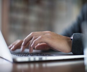Close up hands typing on a laptop