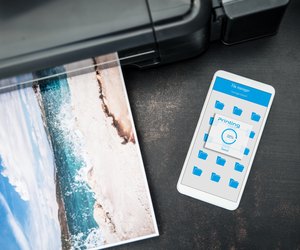 Smartphone connected to the wireless printer is laying on the desk
