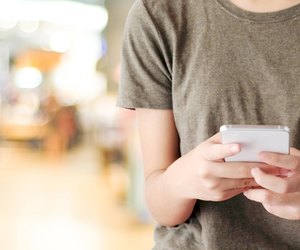 Hand using smart phone over blur store with bokeh light background, business and technology concept, digital marketing, seo, e-commerce, network, internet of things