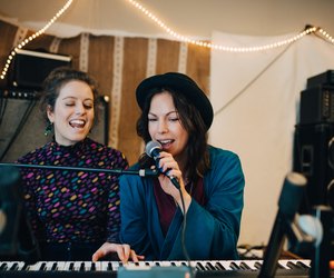 Performers playing piano and singing while practicing in studio