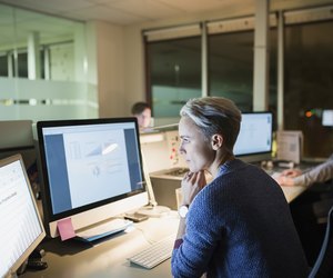 Businesswoman working late at computers in office