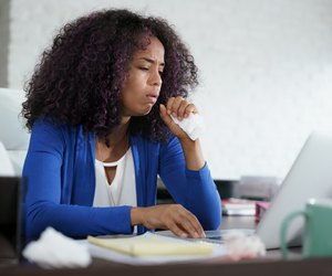 African American Woman Working At Home Coughing And Sneezing