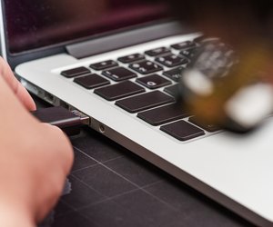 USB flash memory drive plugged into a computer laptop port.