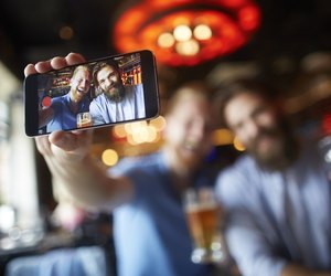 Male friends in the bar posing for a selfie