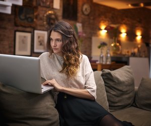 Woman using laptop on couch at home