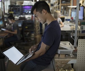 Male engineer working at laptop in workshop