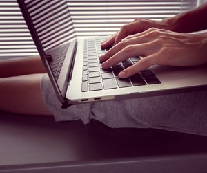 girl holds a MacBook Pro Retina on her lap and something prints