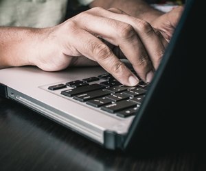 Man typing on an Apple MacBook