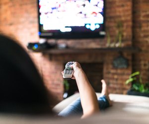 woman relaxing online on sofa reading some papers
