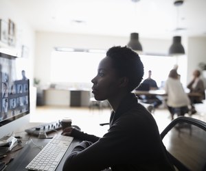 Female photo editor reviewing digital photo proofs on computer in office