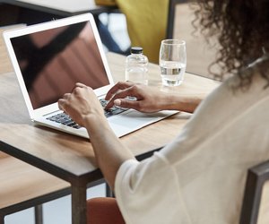 Businesswoman using laptop at table in cafe