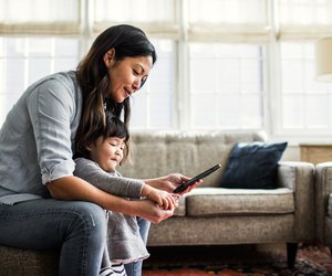 Mother using smartphone with children present