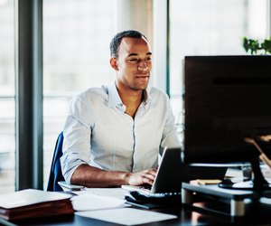 Office Manager Working On Computer At His Desk