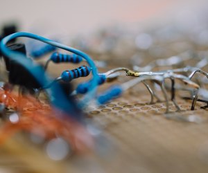 Blue colored small resistors soldered on a breadboard with small transistors