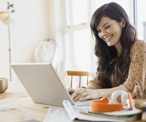 Smiling woman using laptop at table
