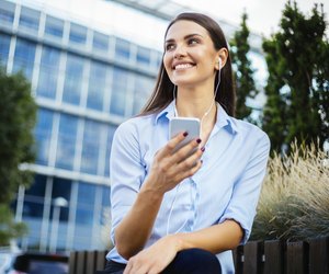 Young businesswoman holding mobile phone and smiling