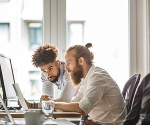 Businessmen discussing over laptop in office