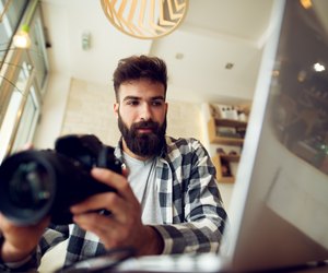 Young photographer beard man editing pictures at his home.