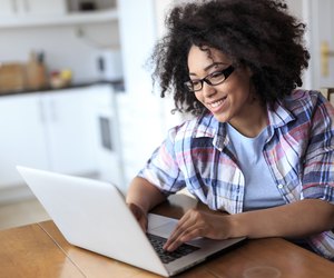 Woman with eyeglasses using laptop at home