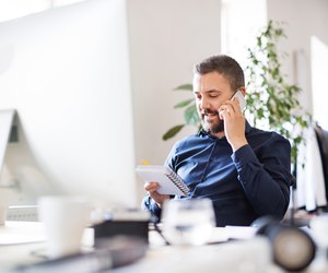 Businessman in wheelchair at the desk in his office.