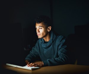 Young man working on computer late at night