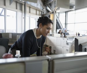 Businesswoman using computer in office cubicle
