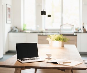 Laptop and notebook on table at home