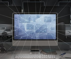 Computer in dark office, network lines radiating