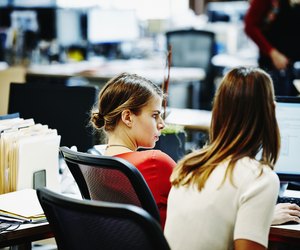 Two businesswomen sitting working on computer